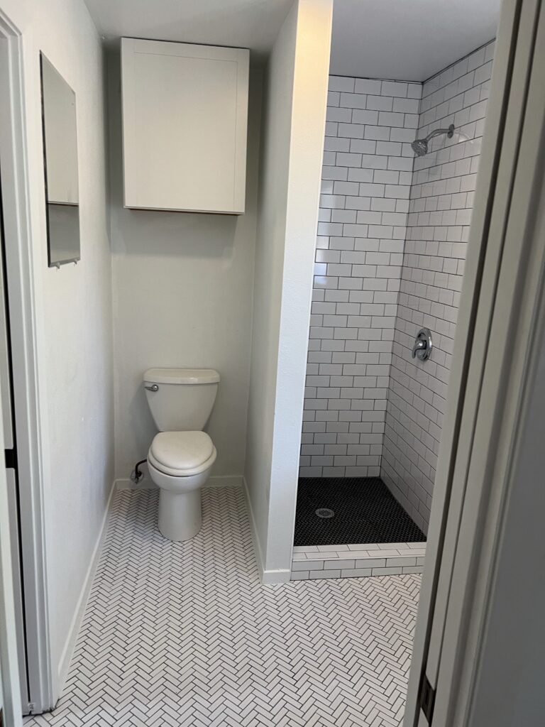 Austin small bathroom remodel with shower tile, tile flooring, bathroom storage, and updated finishes